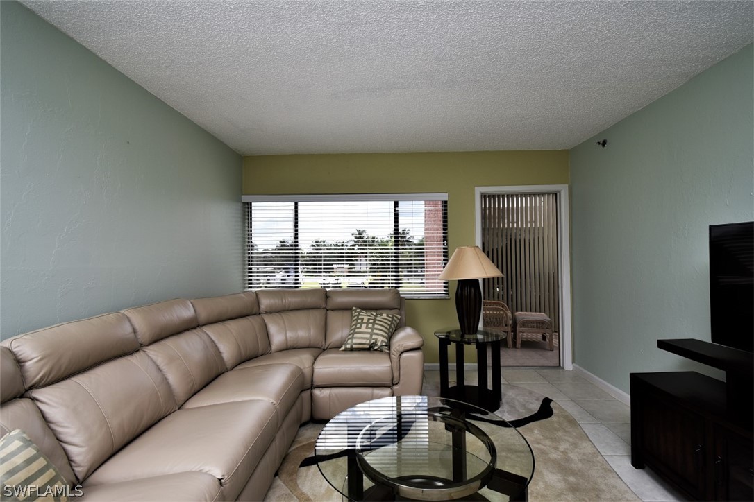 3170 Matecumbe Key Road, Unit 123 Punta Gorda, FL 33955 - Photo 12 of 25 a living room with furniture and a flat screen tv