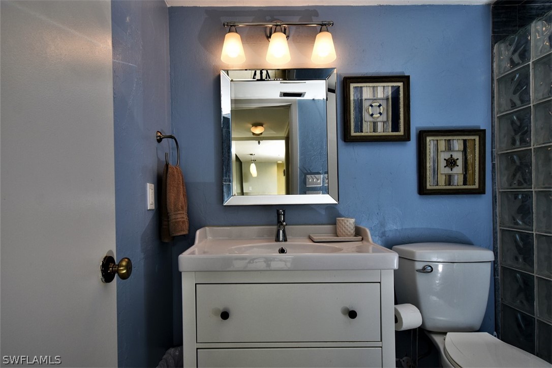 3170 Matecumbe Key Road, Unit 123 Punta Gorda, FL 33955 - Photo 16 of 25 a bathroom with a toilet sink and mirror