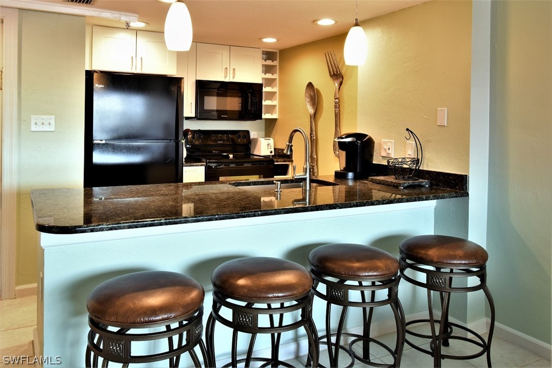 3170 Matecumbe Key Road, Unit 123 Punta Gorda, FL 33955 - Photo 3 of 25 a kitchen with stainless steel appliances granite countertop a table and chairs in it
