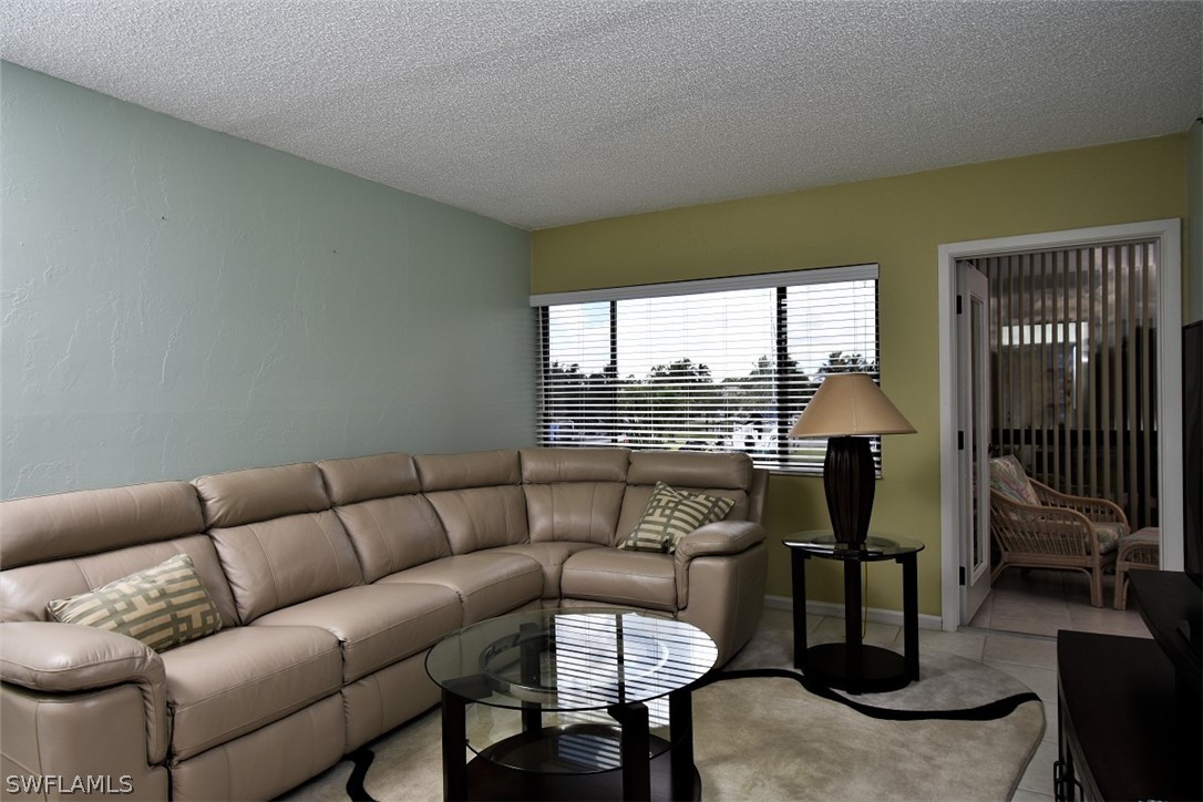 3170 Matecumbe Key Road, Unit 123 Punta Gorda, FL 33955 - Photo 9 of 25 a living room with furniture and a floor to ceiling window