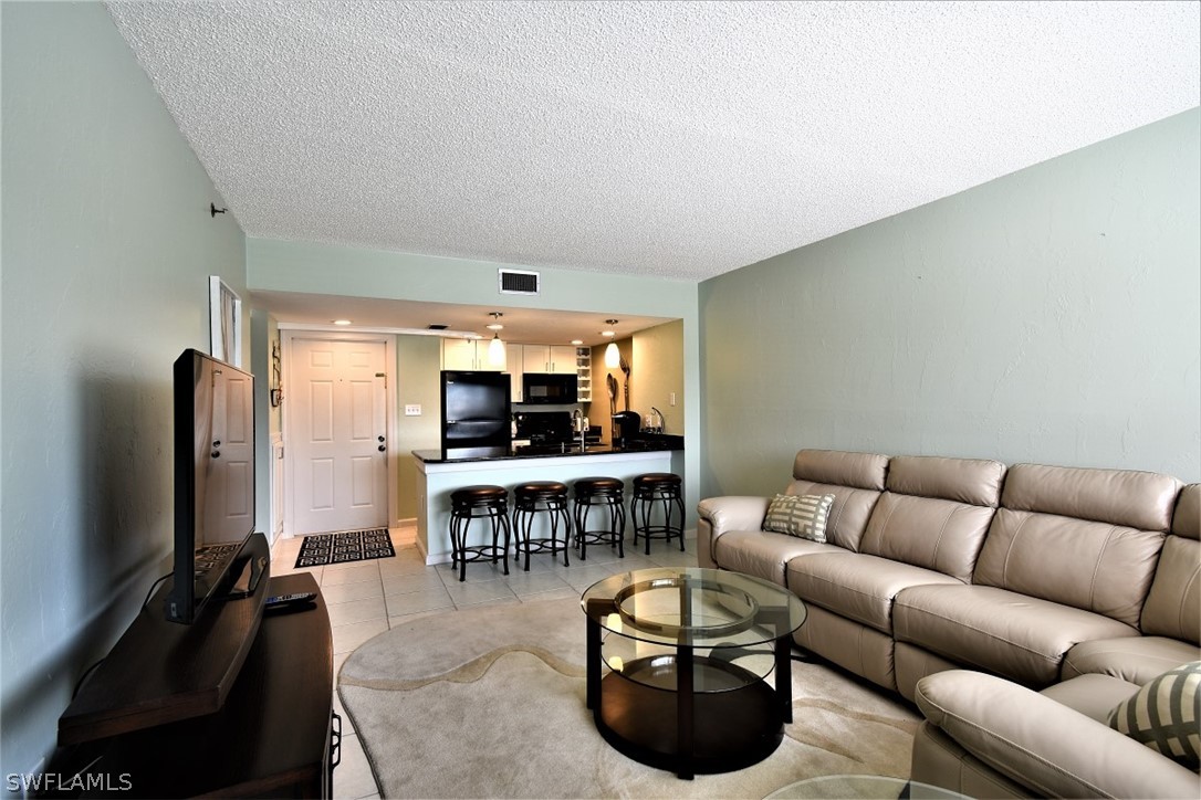3170 Matecumbe Key Road, Unit 123 Punta Gorda, FL 33955 - Photo 10 of 25 a living room with furniture a flat screen tv and kitchen view