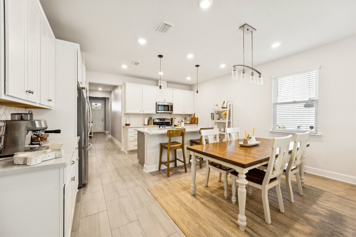 75968 Saffron Lane Yulee, FL 32097 - Photo 13 of 67 a dining room with stainless steel appliances kitchen island granite countertop a table chairs and a living room view