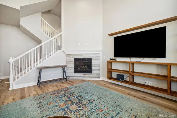 a kitchen with stainless steel appliances kitchen island granite countertop a refrigerator a stove a sink dishwasher and white cabinets with wooden floor