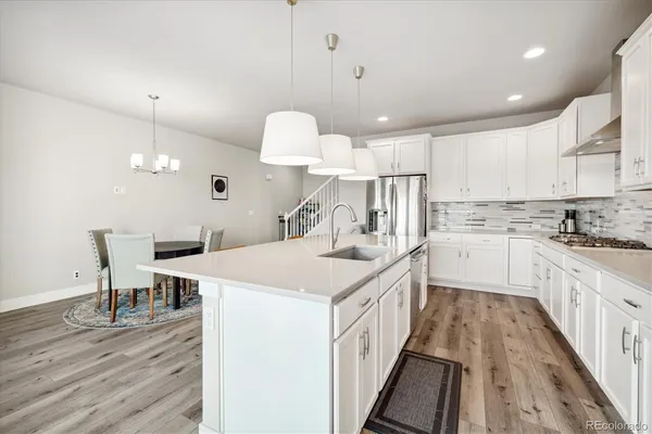 a view of a dining room with furniture a chandelier and wooden floor