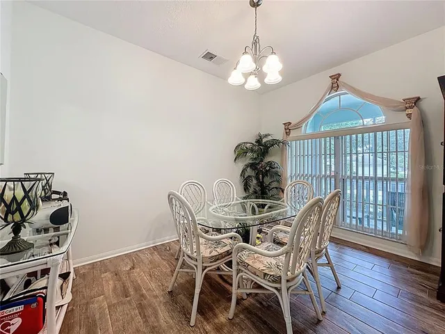 a view of a living room and a kitchen with wooden floor