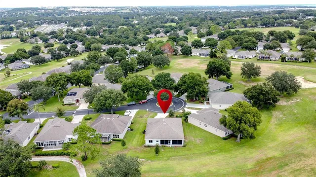 an aerial view of residential houses with outdoor space and trees