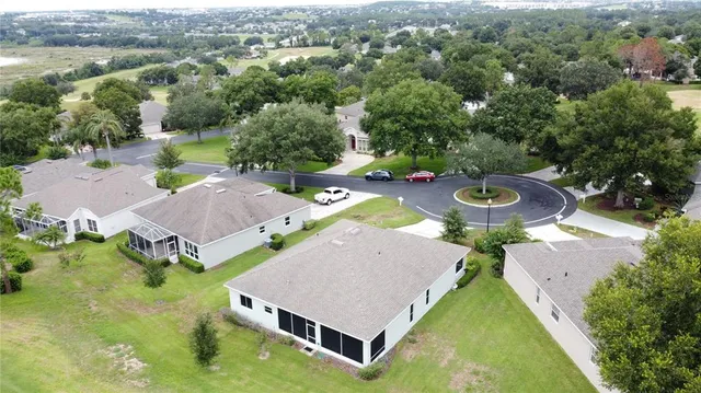 a living room with stainless steel appliances furniture a rug and a view of kitchen