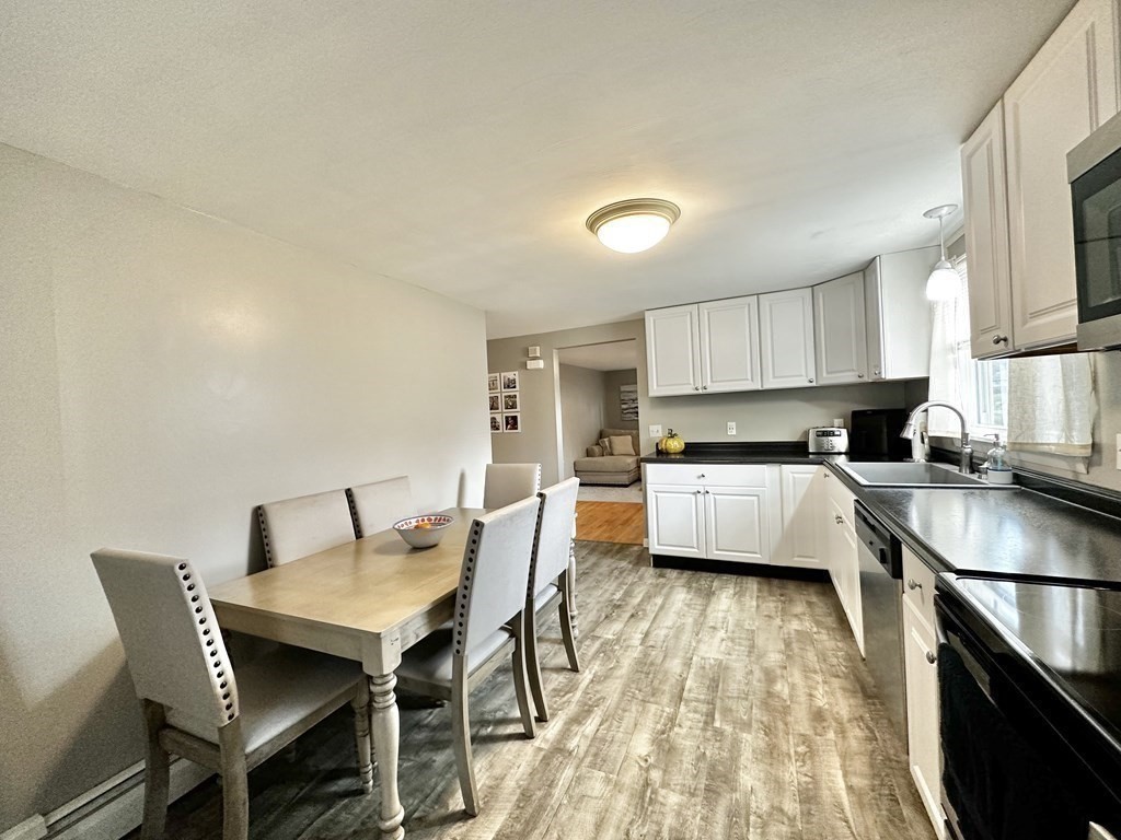 174 Chudy Street Three Rivers, MA 01080 - Photo 16 of 31 a kitchen with a table chairs a sink dishwasher stove and cabinets with wooden floor