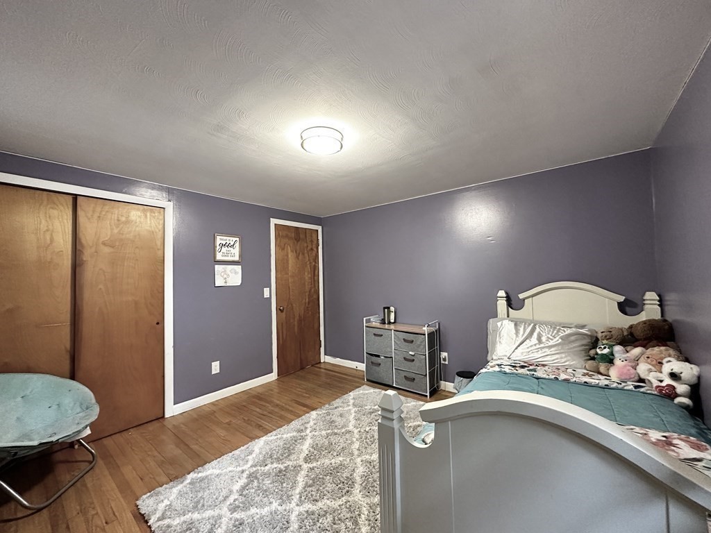 174 Chudy Street Three Rivers, MA 01080 - Photo 21 of 31 a room with a bed and wooden floor