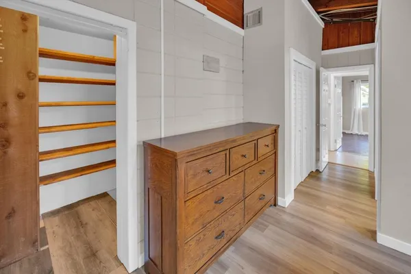 a hallway with closet and wooden floor
