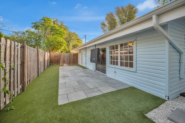 a backyard of a house with plants and wooden fence