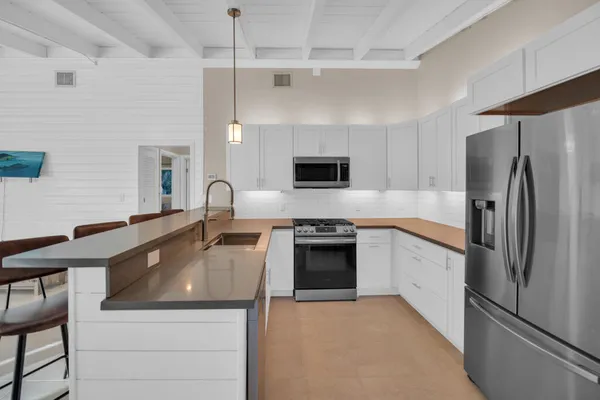 a kitchen with stainless steel appliances a refrigerator sink and stove