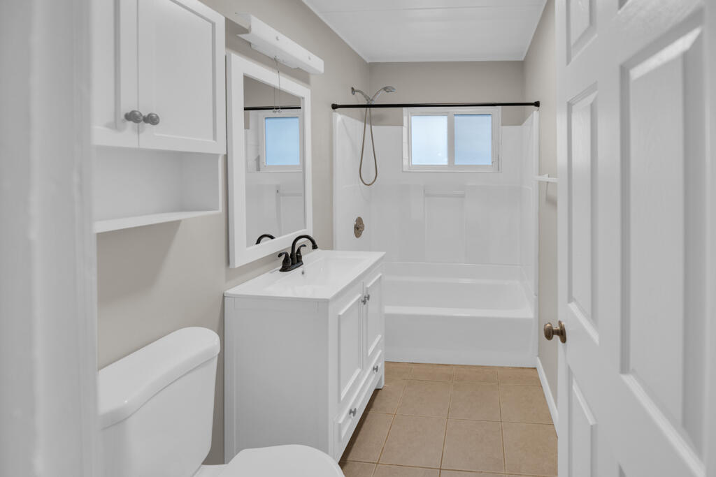 124 South Hammock Road Islamorada, FL 33036 - Photo 10 of 23 a bathroom with a bathtub a sink a toilet and a mirror