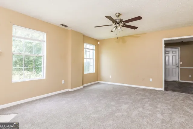 a view of a room with a chandelier fan and refrigerator