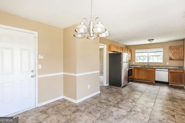 a kitchen with granite countertop stainless steel appliances a sink stove and cabinets