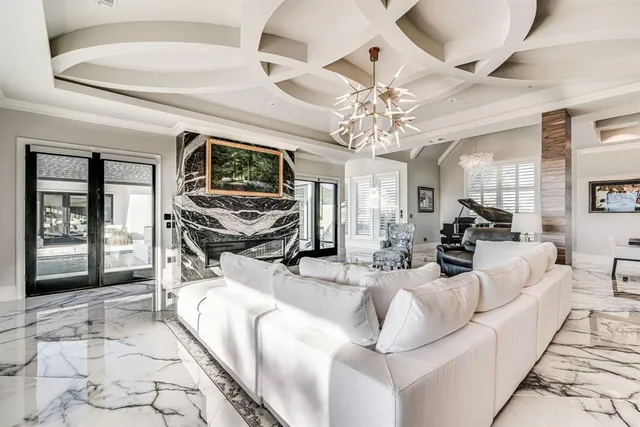 a living room with furniture a flat screen tv and floor to ceiling window