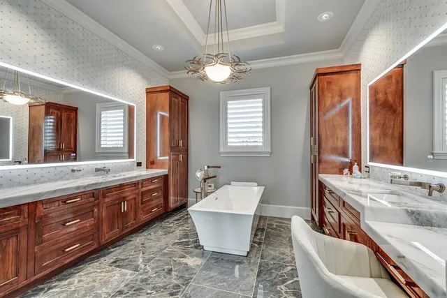 a spacious bathroom with a double vanity sink a large mirror and a bathtub
