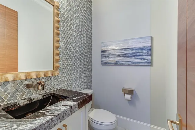 a bathroom with a granite countertop sink a toilet a mirror and bathtub