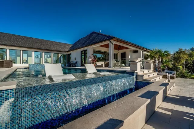 a view of a house with backyard and sitting area