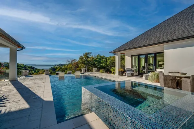 a view of a patio with dining table and chairs with couches potted plants and large tree