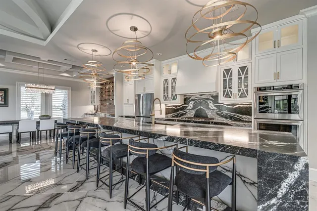 a kitchen with a dining table chairs cabinets and stainless steel appliances