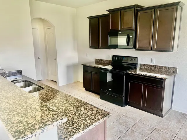 a kitchen with stainless steel appliances granite countertop a stove and a microwave