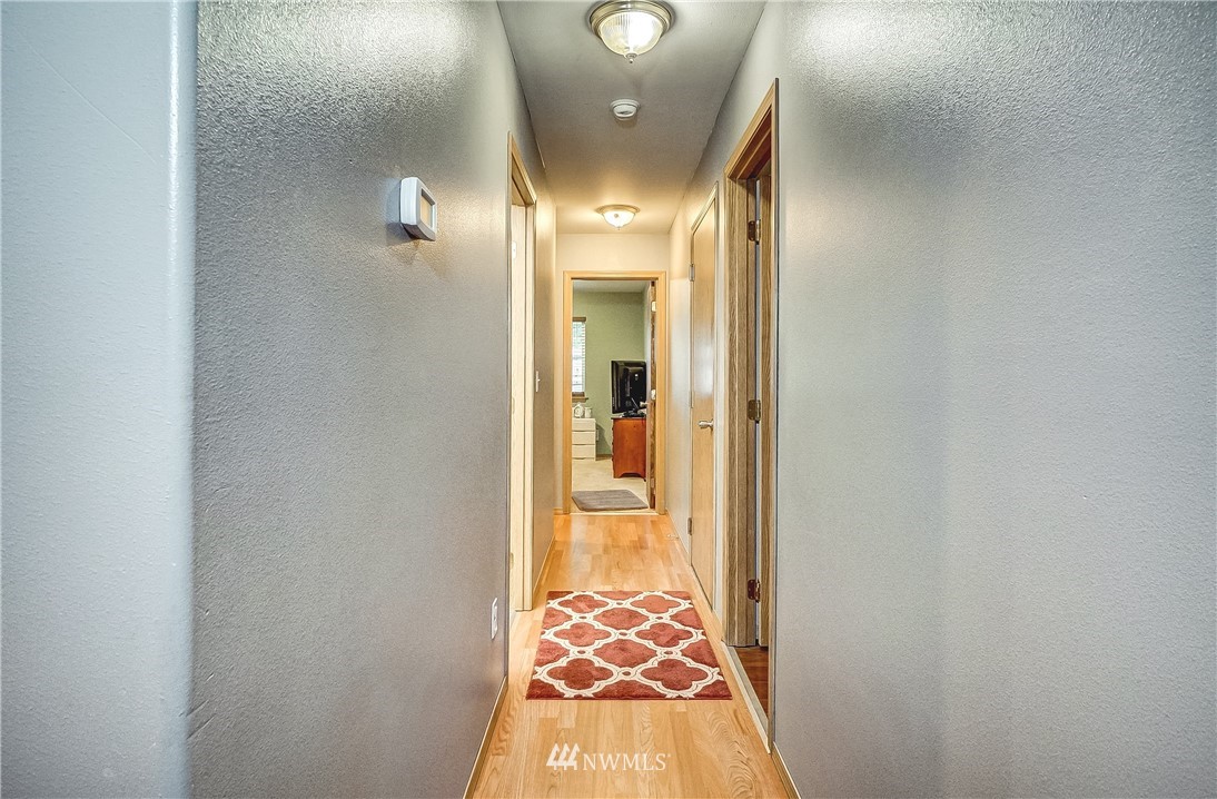 18818 Loganberry Street Southwest Rochester, WA 98579 - Photo 14 of 38 a view of a hallway with wooden floor and a bathroom
