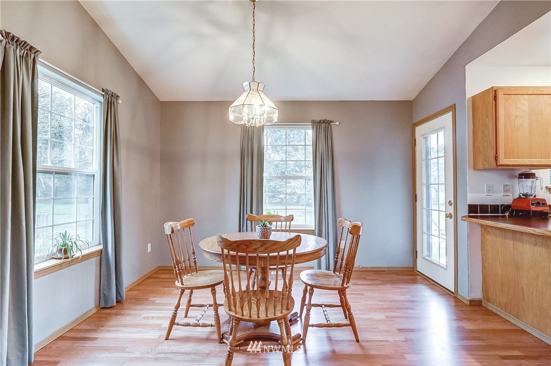 18818 Loganberry Street Southwest Rochester, WA 98579 - Photo 8 of 38 a dining room with furniture a chandelier and wooden floor