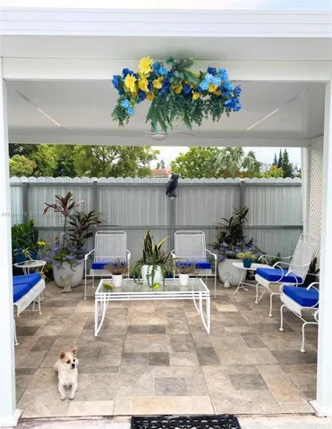 a view of a patio with table and chairs potted plants