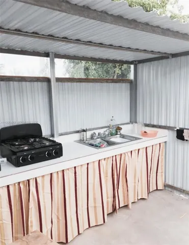 a kitchen with a stove a sink and a window
