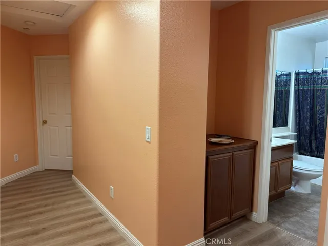 a view of a hallway with wooden floor and staircase