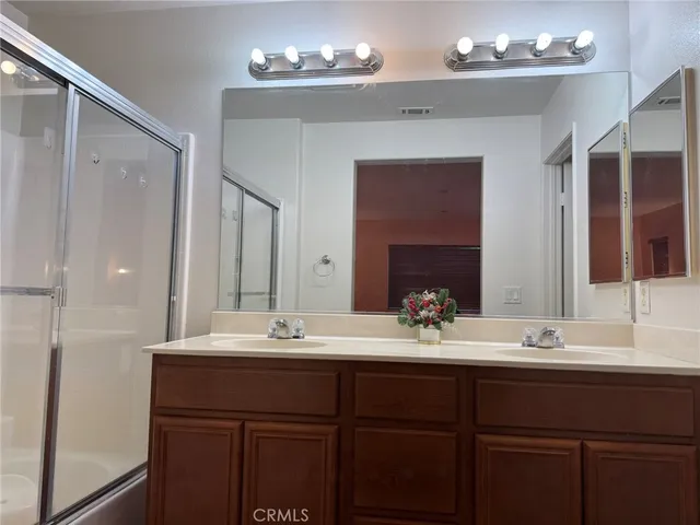 a bathroom with a double vanity sink toilet and a mirror