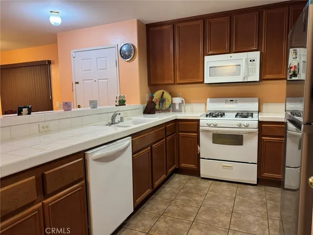 a living room with furniture a flat screen tv and kitchen view