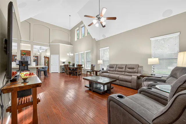 a living room with furniture kitchen view and a wooden floor