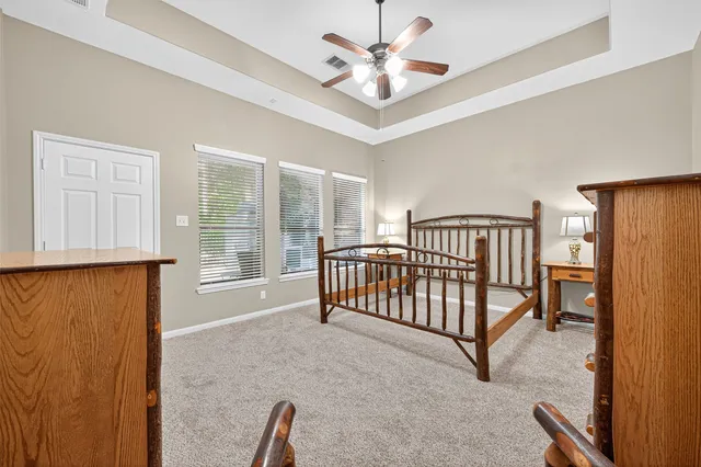 wooden floor with chandelier fan and windows