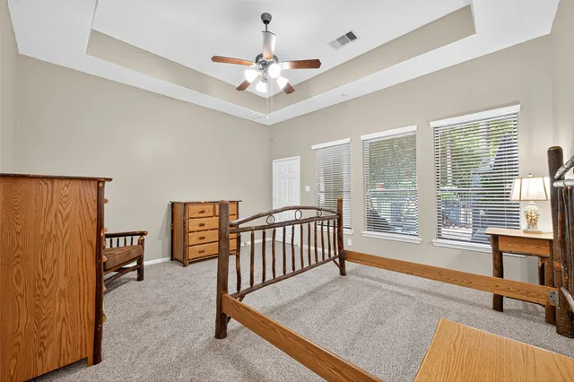 a spacious bedroom with a bed and a chandelier
