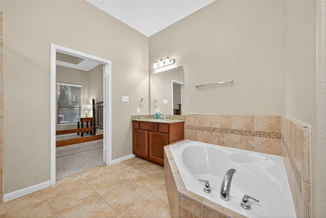 a bathroom with a tub sink and mirror