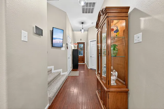a view of a hallway with wooden floor and staircase