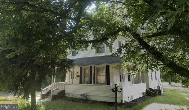 a view of house with backyard and a tree