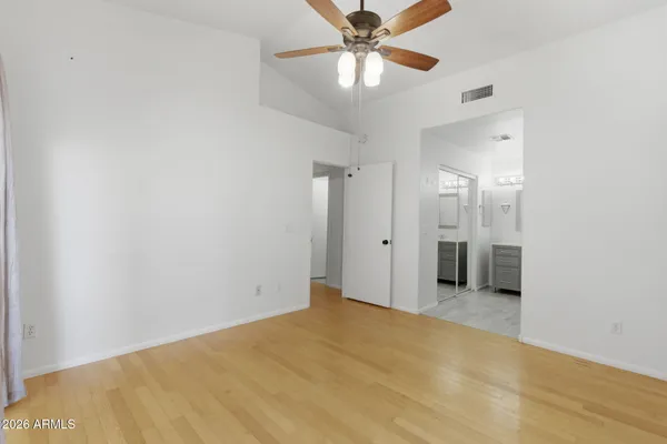 a view of a room with a ceiling fan and a hardwood floor
