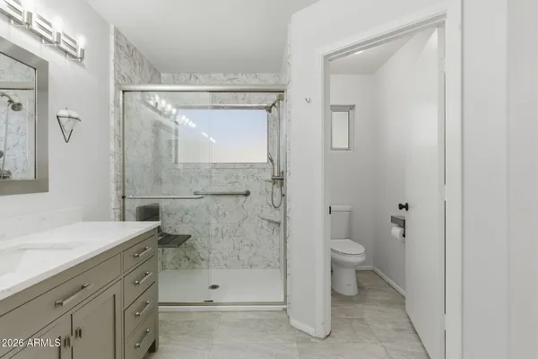 a bathroom with a toilet a sink and glass door