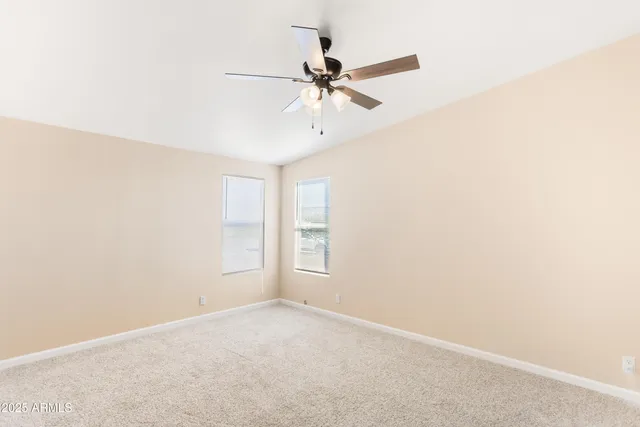 an empty room with a window and a fan