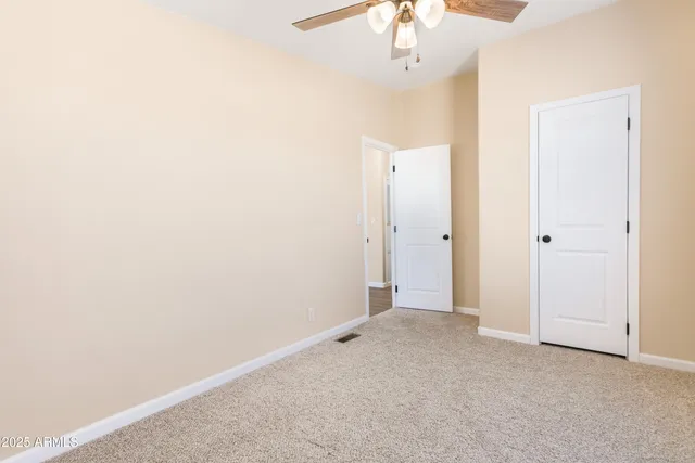 an empty room with a window and a fan
