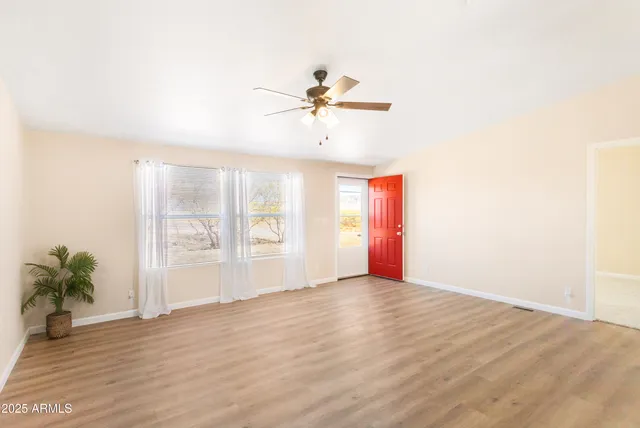 a view of a room with a window and wooden floor