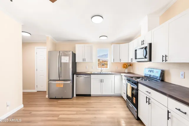 a kitchen with stainless steel appliances granite countertop a refrigerator sink and stove