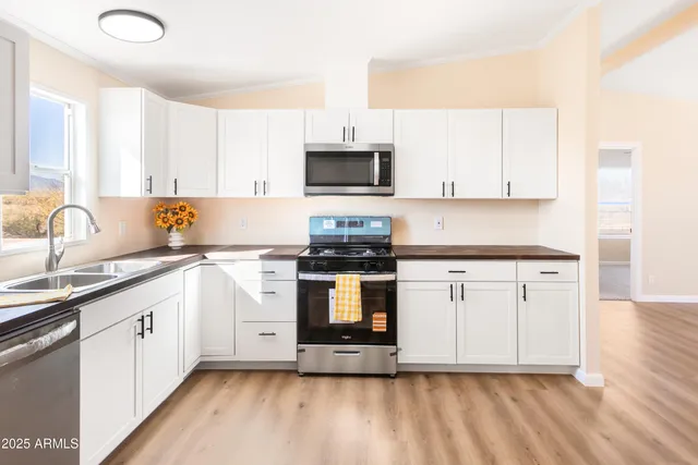 a kitchen with granite countertop a stove top oven sink and cabinets