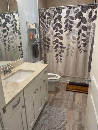 a bathroom with a granite countertop sink toilet and shower