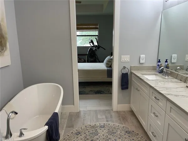 a en suite bathroom with a granite countertop sink and a mirror
