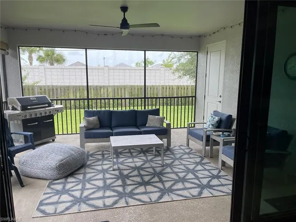 a living room with furniture and a floor to ceiling window