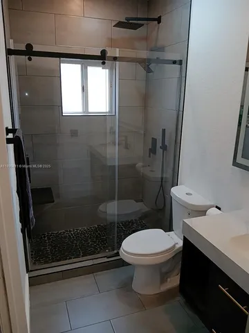 a bathroom with a toilet and a shower